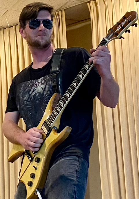 Westad on stage in sunglasses, playing a natural-finish B.C. Rich