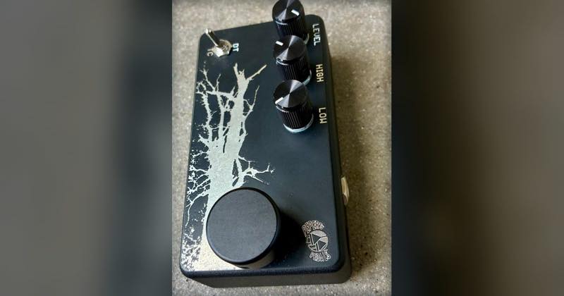 The Pepers' Pedals Dirty Tree, the black version with the exposed metal tree, standing on concrete and shot from above: level, high and low knobs, the TC/DT toggle and the footswitch